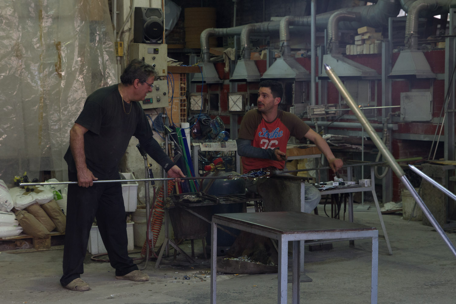 Dos artesanos en plena faena en un taller de cristal de Murano, Italia