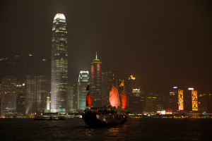 Vista nocturna de un junco atravesando Victoria Harbour, Hong Kong